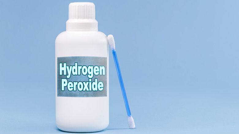 Bottle of hydrogen peroxide with Q-tip