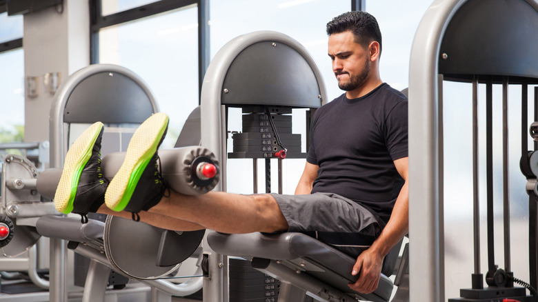 A man uses a leg extension machine