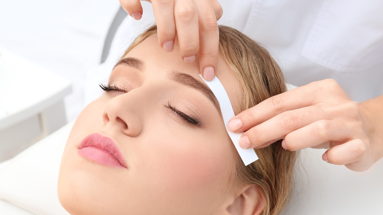 Woman getting eyebrow waxed