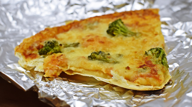 A slice of veggie pizza on a sheet of tin foil