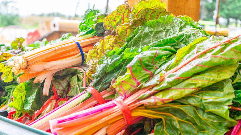 a woman shopping for swiss chard and kale