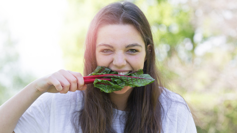 a women eating swiss chard 