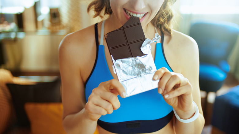 Woman eating chocolate before workout