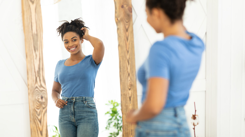 Woman looks confidently in the mirror