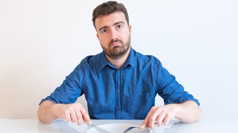 man without food on  plate
