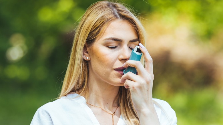 A woman using an inhaler