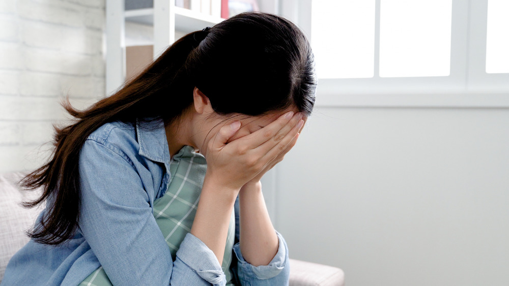 Woman covering her face with her hands