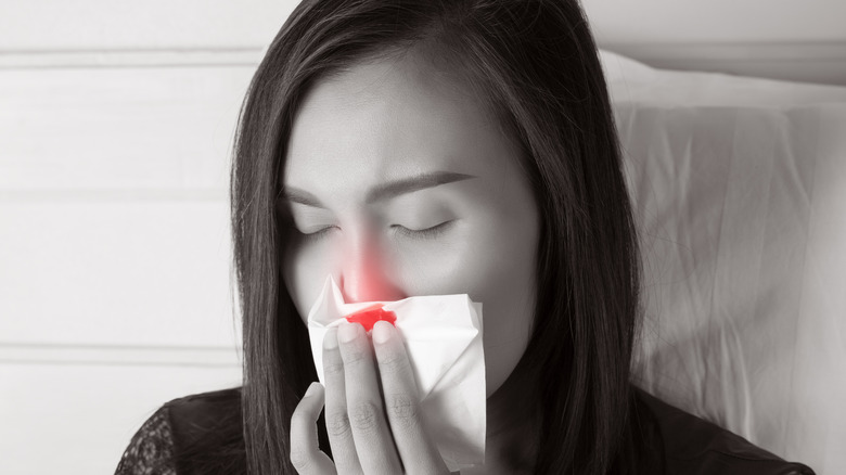 Black and white image of woman with nosebleed