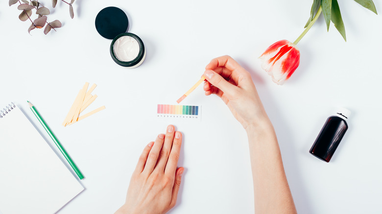 Hands holding pH testing strip