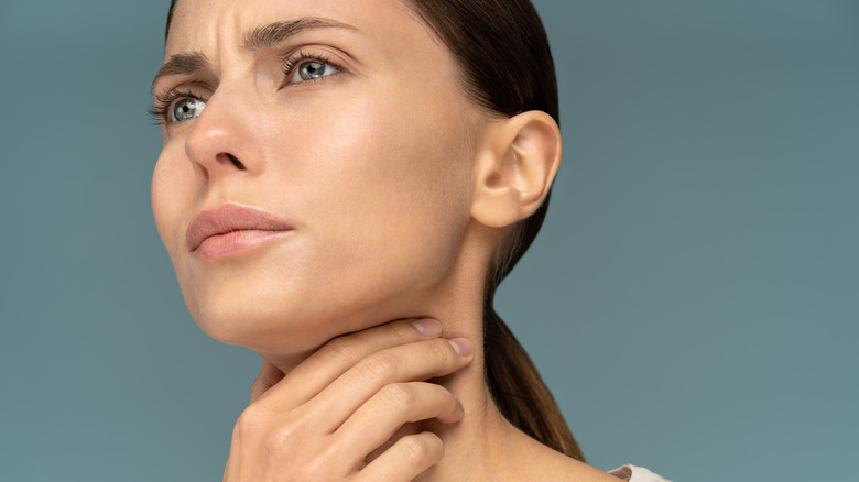woman touching her neck