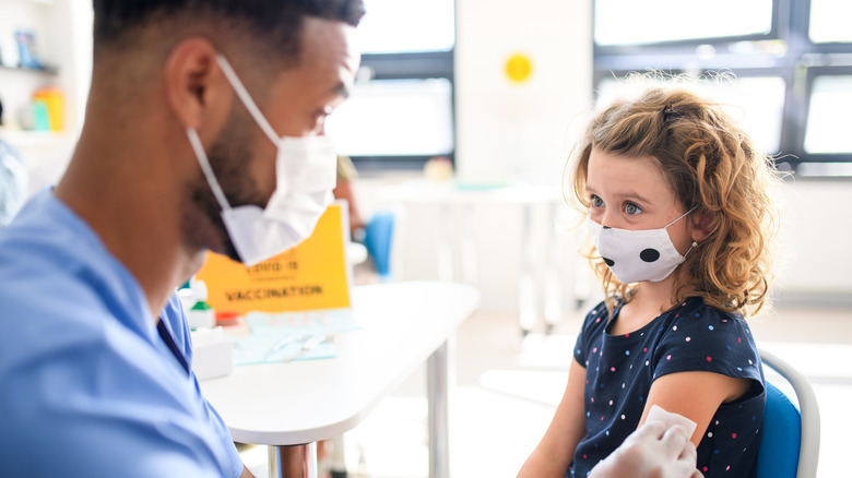 young girl sitting down for vaccination