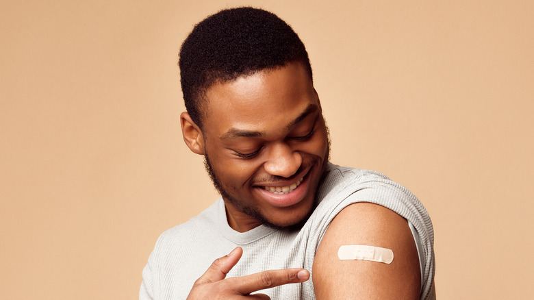 Man pointing to covid vaccine injection site