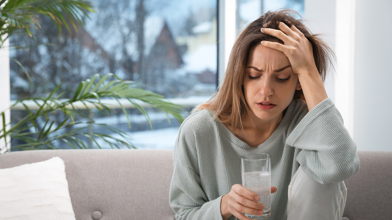 Woman with a hangover drinking water