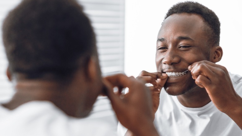 Man flossing teeth