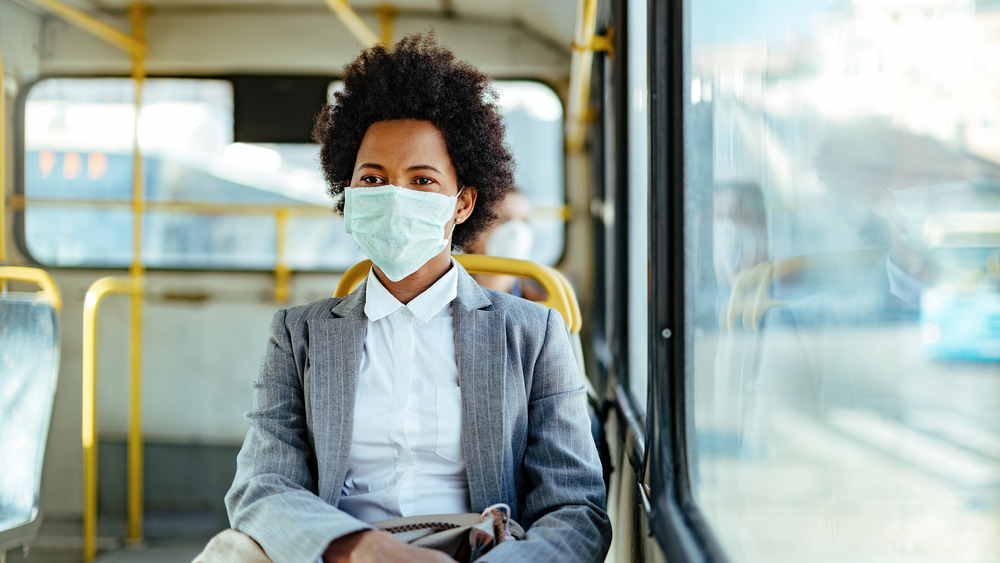 woman wearing a face mask on a bus