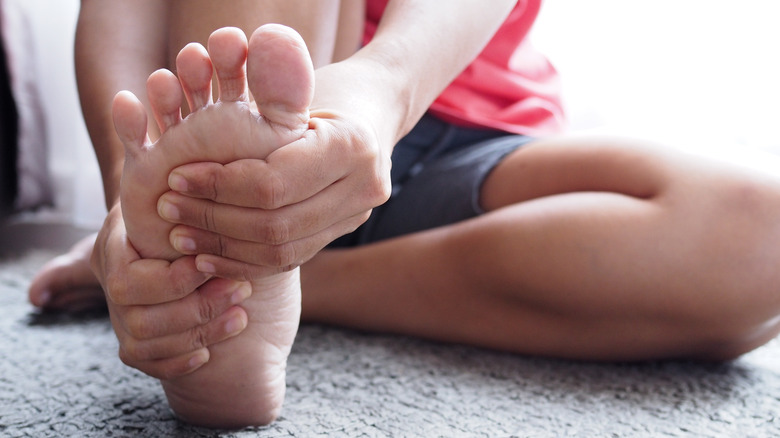 woman massaging pained foot