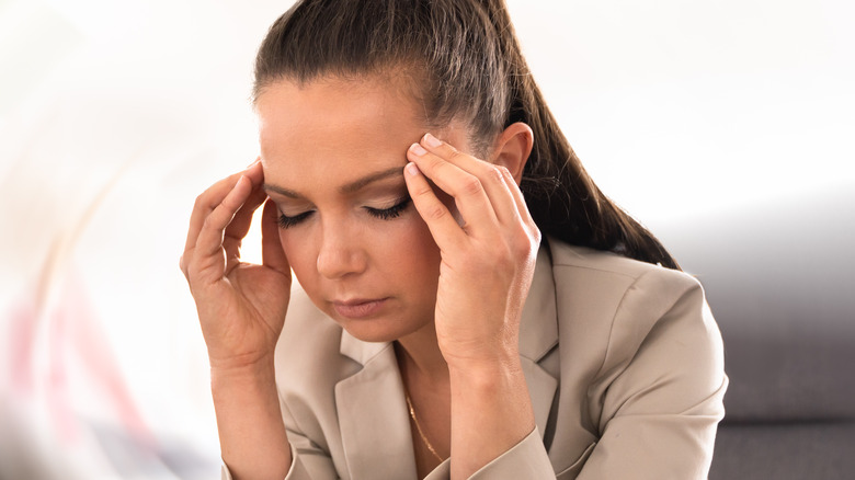 Woman with migraine holding her head 