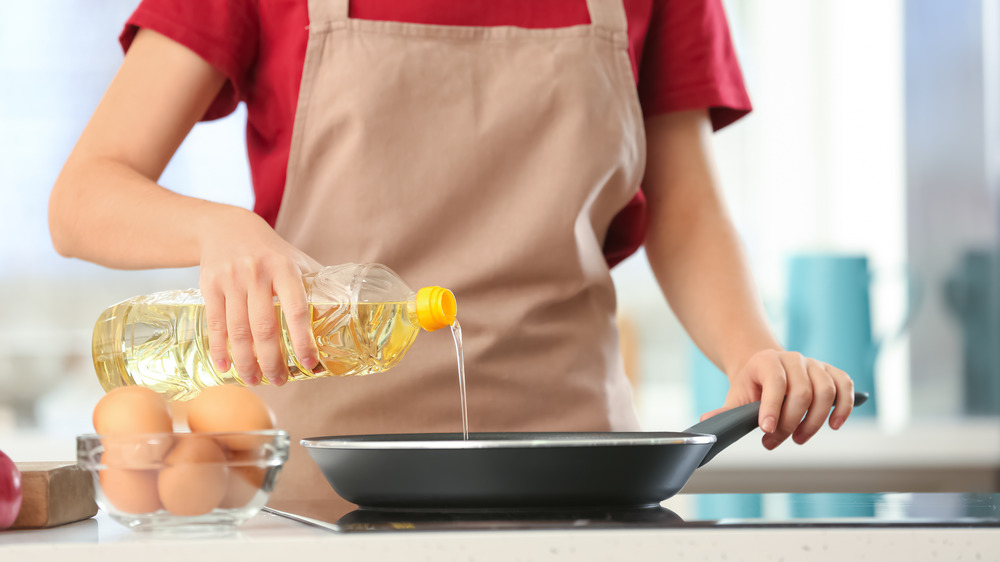 woman pouring vegetable oil