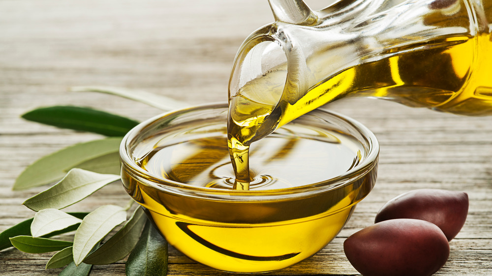 olive oil being poured into bowl