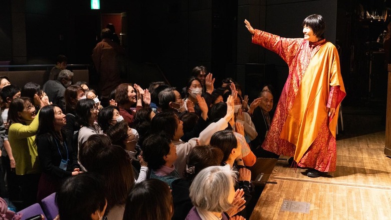 Yogmata Keiko Aikawa blessing a crowd of people at a talk