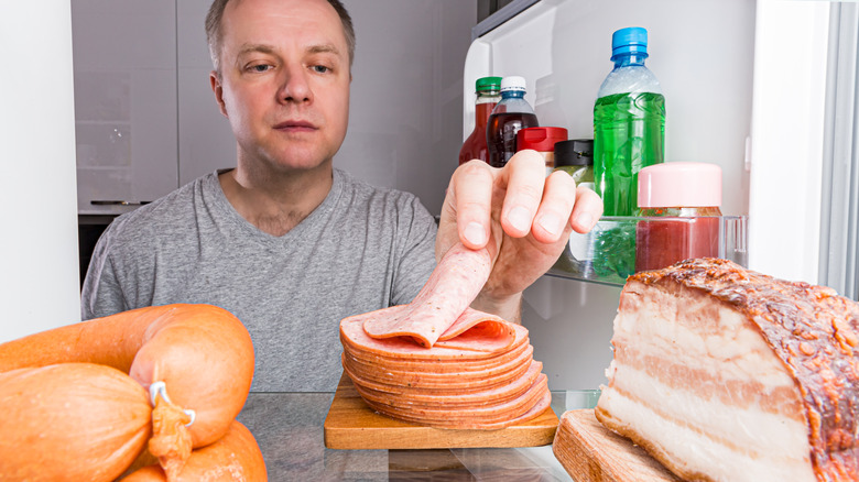 Man taking sliced meat from fridge