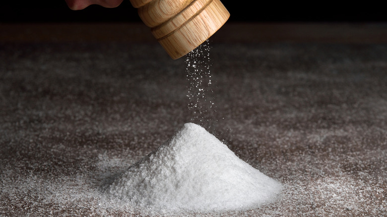 Someone is pouring salt out of a saltshaker