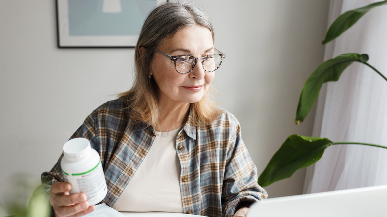 mature woman looking at supplements
