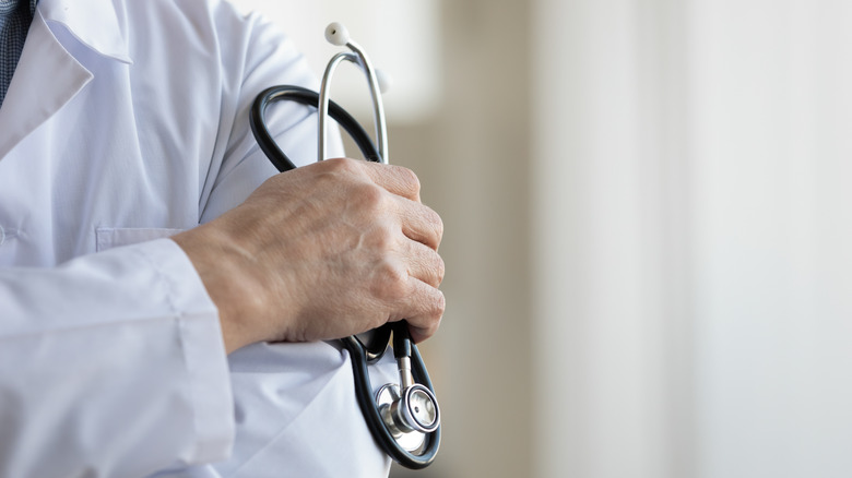 Close up of a doctor's arm with arms crossed and a stethoscope in hand