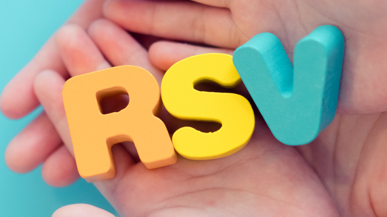 Children's hands holding the letters RSV 