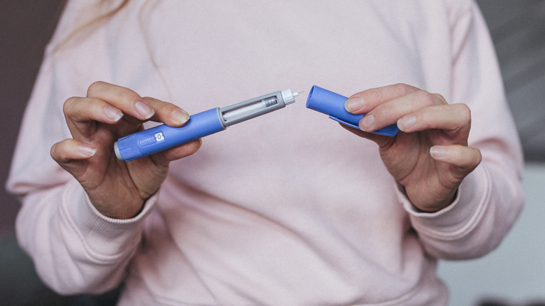 A woman's hands preparing a semaglutide injection pen