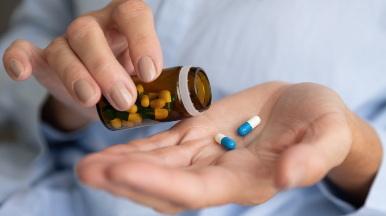 person pouring pills into hand