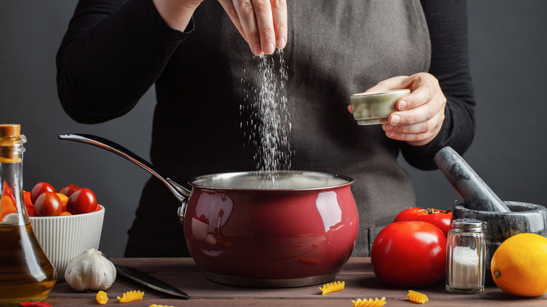 Woman adding salt to food