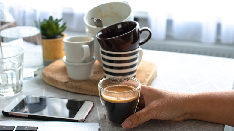 empty coffee cups stacked behind a full cup of coffee