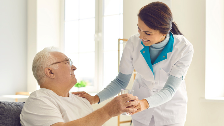 Doctor handing water to patient