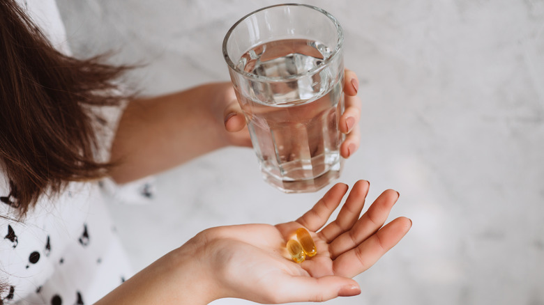 woman holding vitamin D supplements