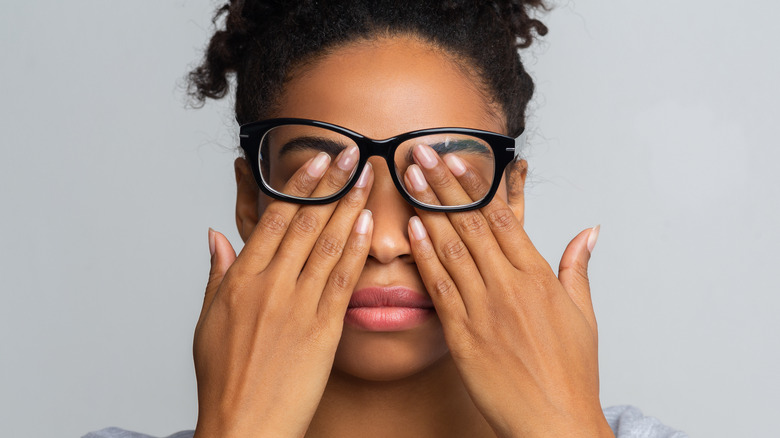 woman holding fingers against eyes