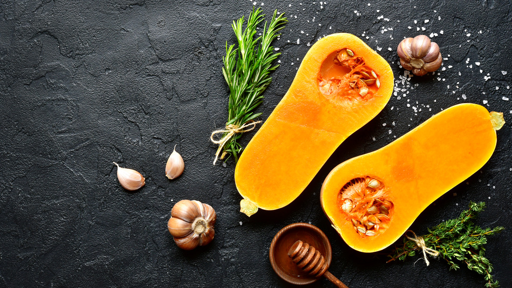 Butternut squash sliced in half with garlic and thyme 