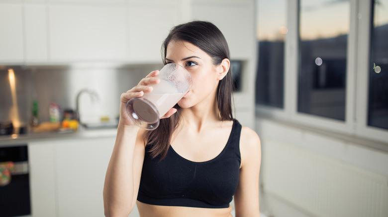 A woman drinks a protein shake