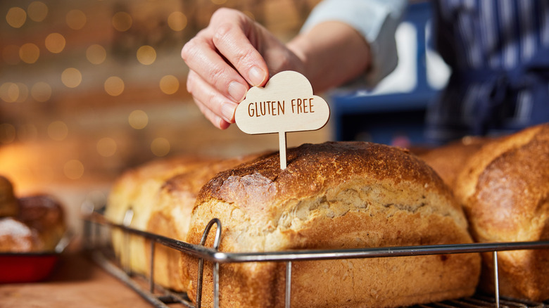 Someone puts a gluten free sign into a loaf of bread