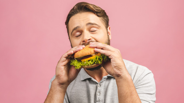 man enjoying a hamburger