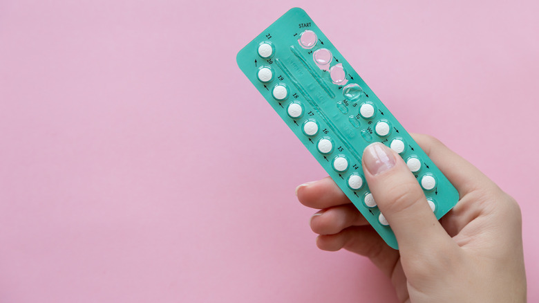 Hand holding birth control pills