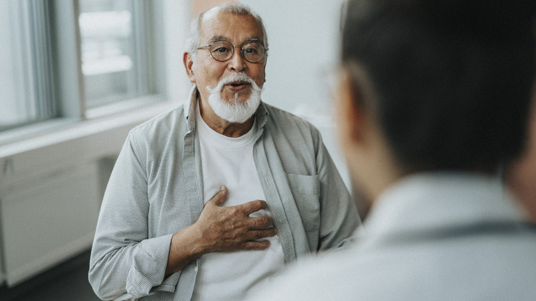 older man speaking with doctor about symptoms