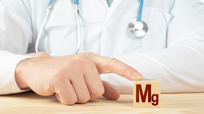 Doctor's finger pointing to a block with "Mg" on it