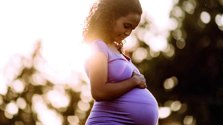 Pregnant person standing outside