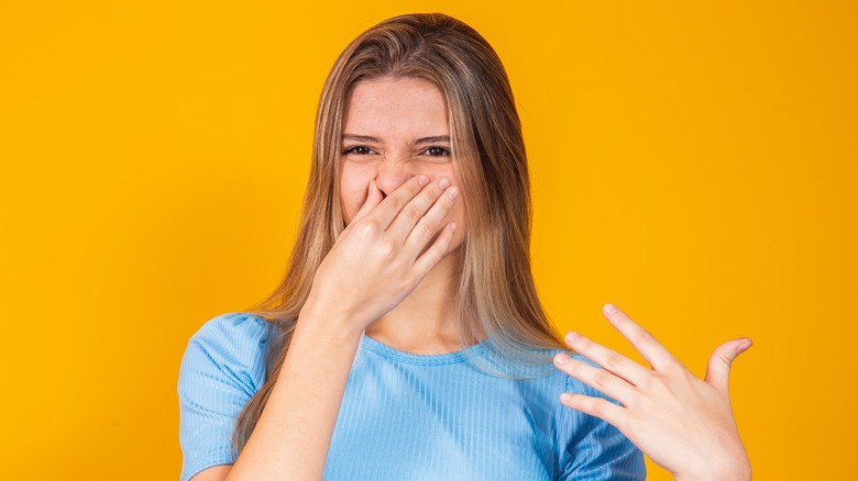 woman holding nose