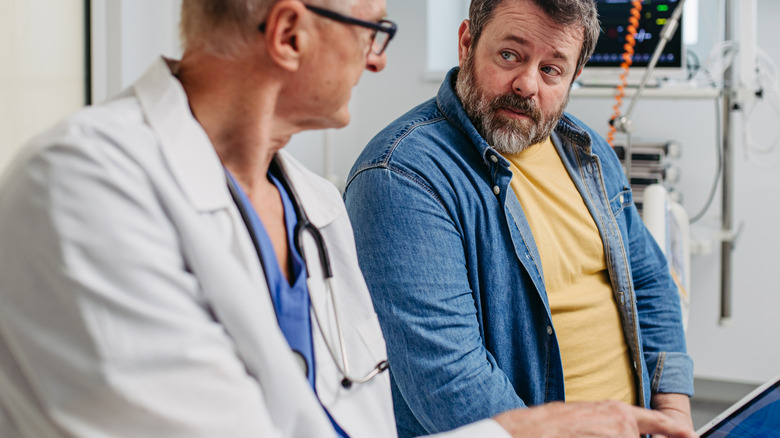 male doctor explaining medical report to male patient