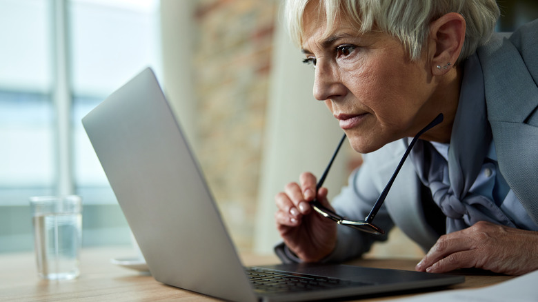 older woman straining to look at her computer screen