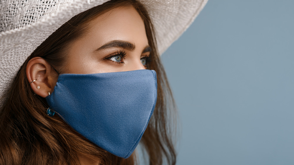 Woman wearing face mask and hat