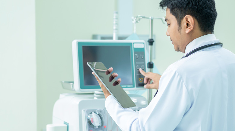 doctor adjusting dialysis machine