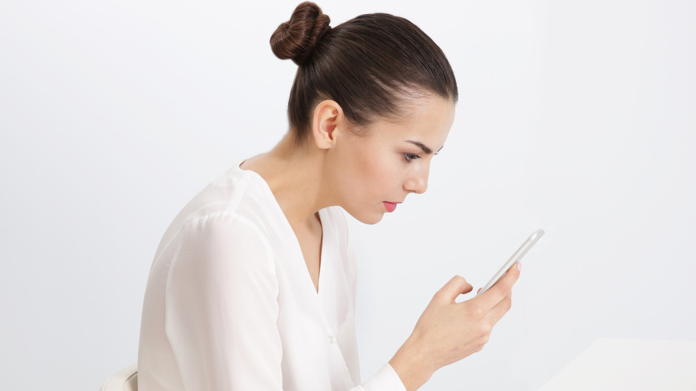 woman slouching, using phone